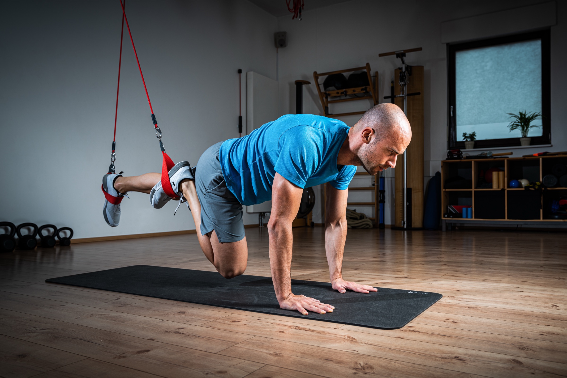 A participant holding a supported plank position in Redcord slings